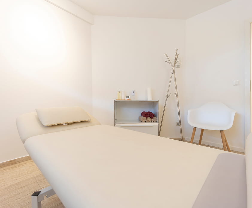 Behandlungsraum mit Therapieliege und Sitzgelegenheit