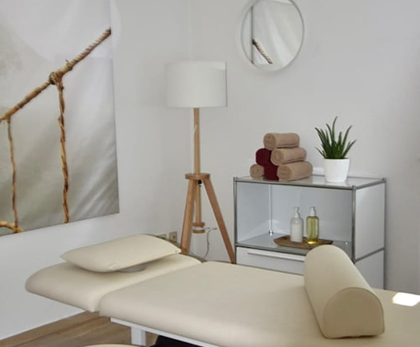 Behandlungsraum mit Therapieliege und Stehlampe