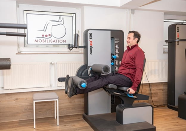 Patient trainiert an einem Gerät im Trainingsbereich