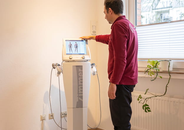 Therapeut bedient ein Elektrotherapiegerät