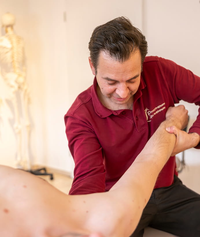 Physiotherapeut behandelt den Arm eines Patienten