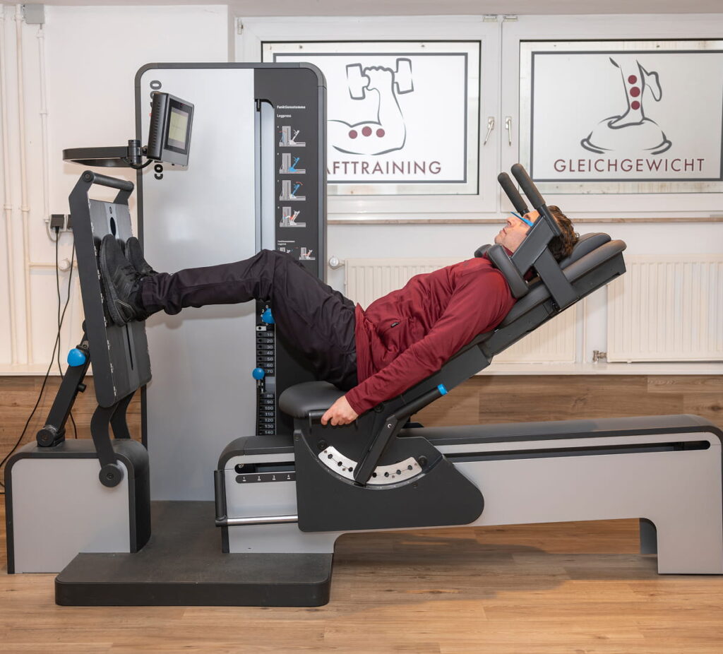 Patient trainiert an der Beinpresse im Trainingsbereich