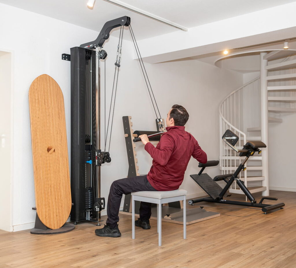 Patient trainiert am Seilzug im Trainingsraum