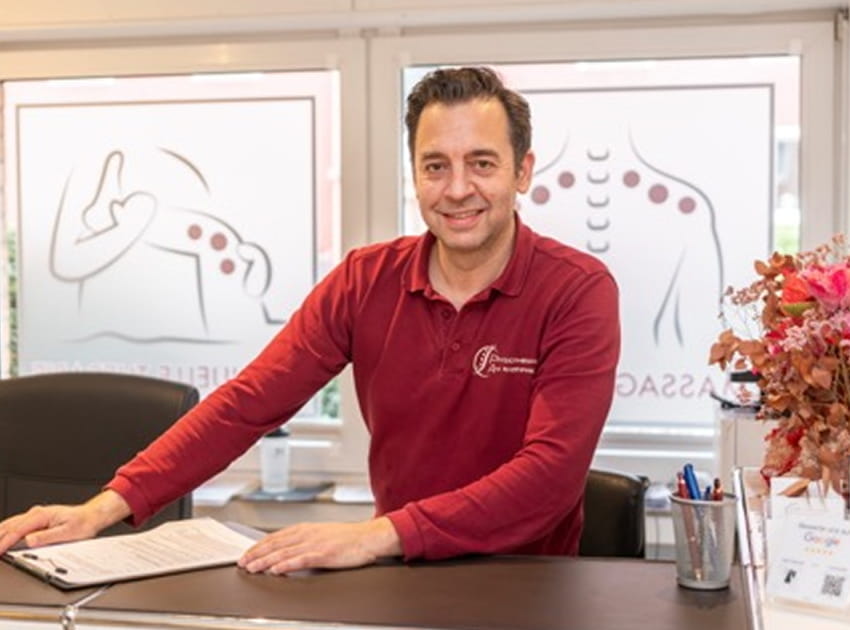 Physiotherapeut am Empfangstresen der Praxis am Rheinpark in Düsseldorf-Golzheim